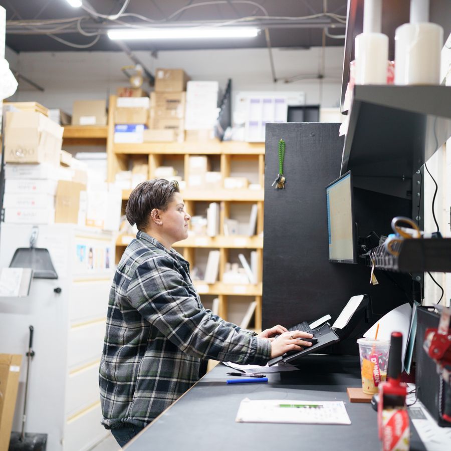 A group of people are sitting at a counter in a store.