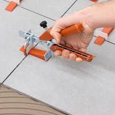 A person is using a tile leveling tool on a tile floor.
