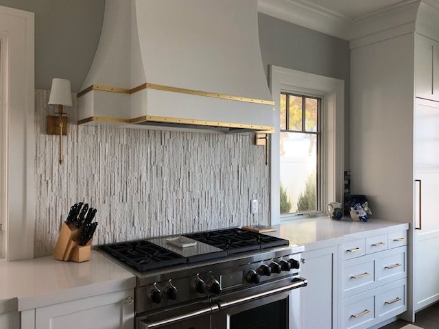 A kitchen with a stove top oven and a window.
