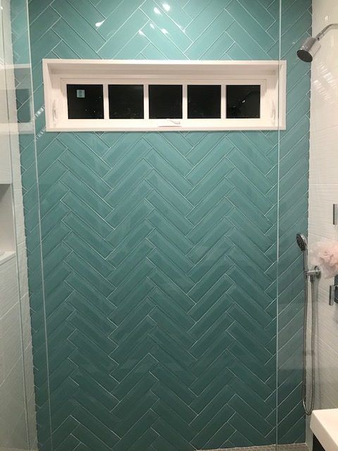 A bathroom with blue tiles and a shower head