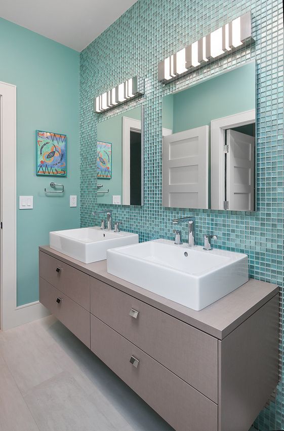 A bathroom with two sinks and a mirror.