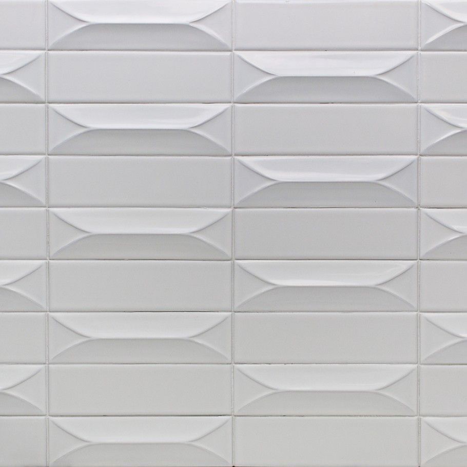 A close up of a white tile wall with a geometric pattern.