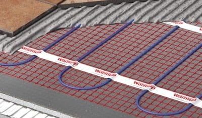 A close up of a heating system on a tiled floor.