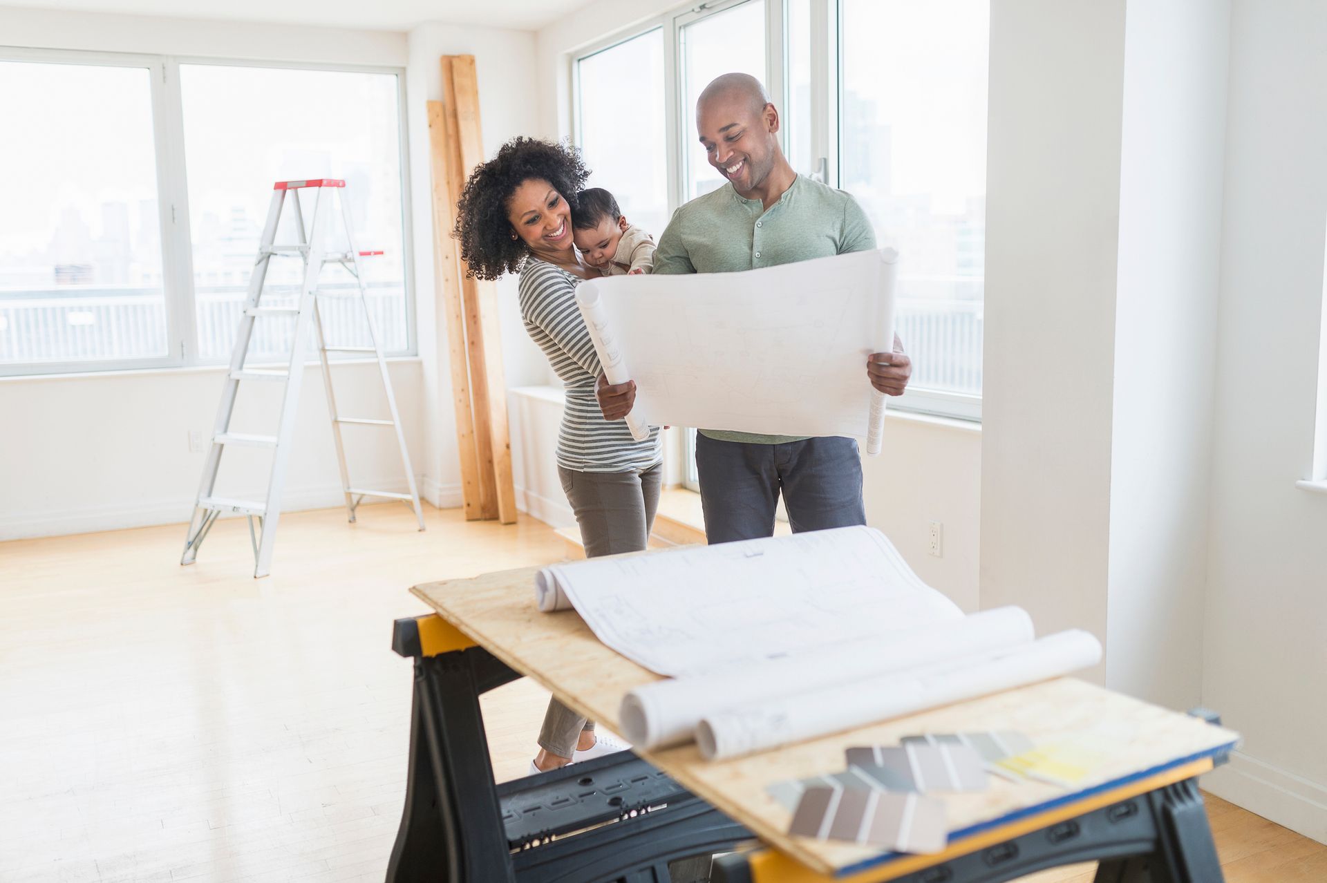 Family examining blueprints in new home.