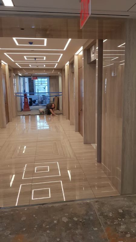 A man is laying on the floor in a hallway in a building.
