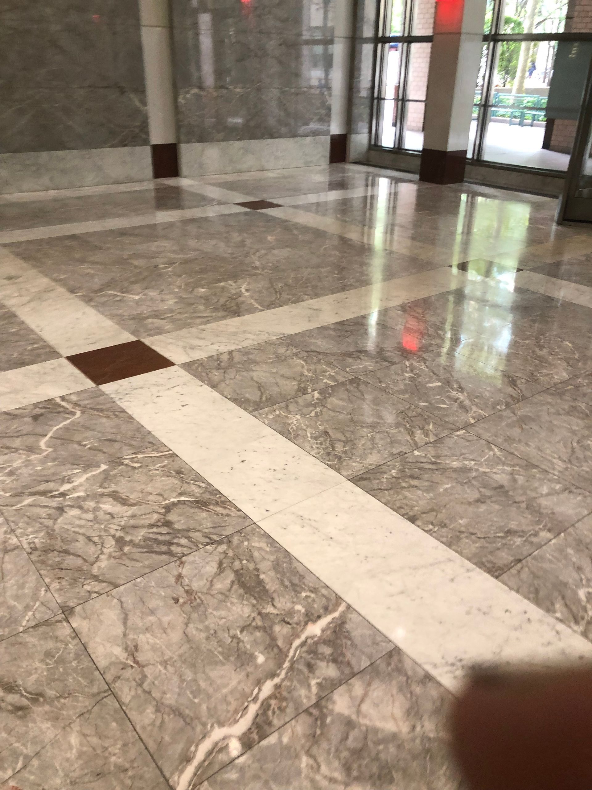 A person is standing in a room with a marble floor.
