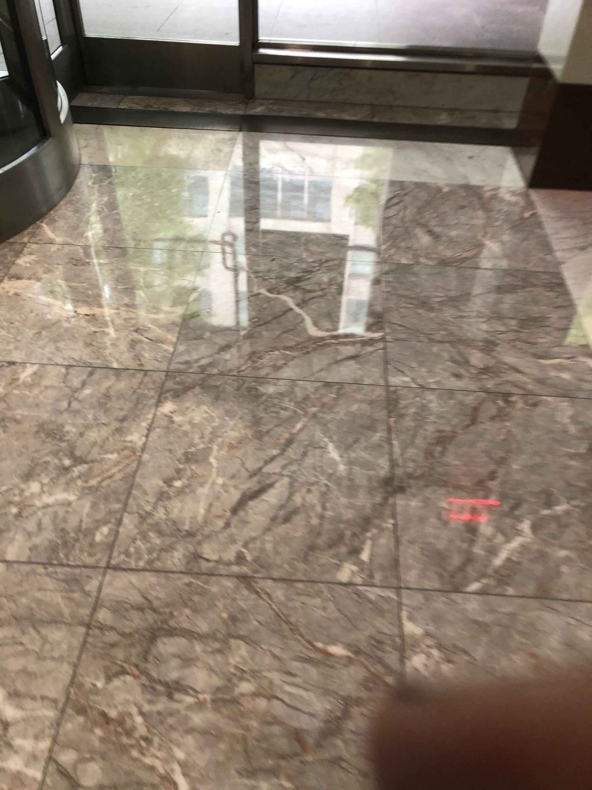 A person is standing on a tiled floor in a building.