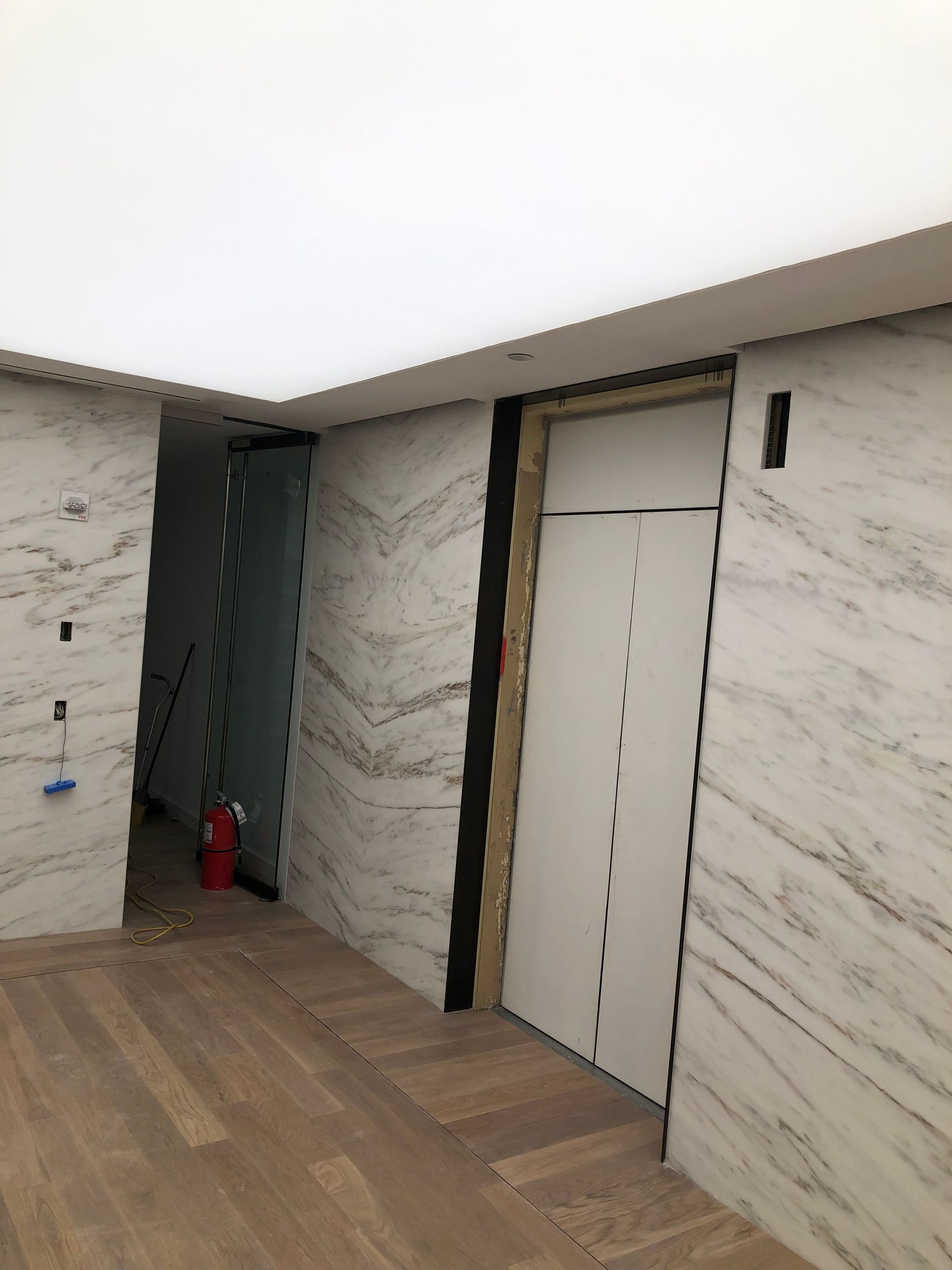 A hallway with marble walls and wooden floors