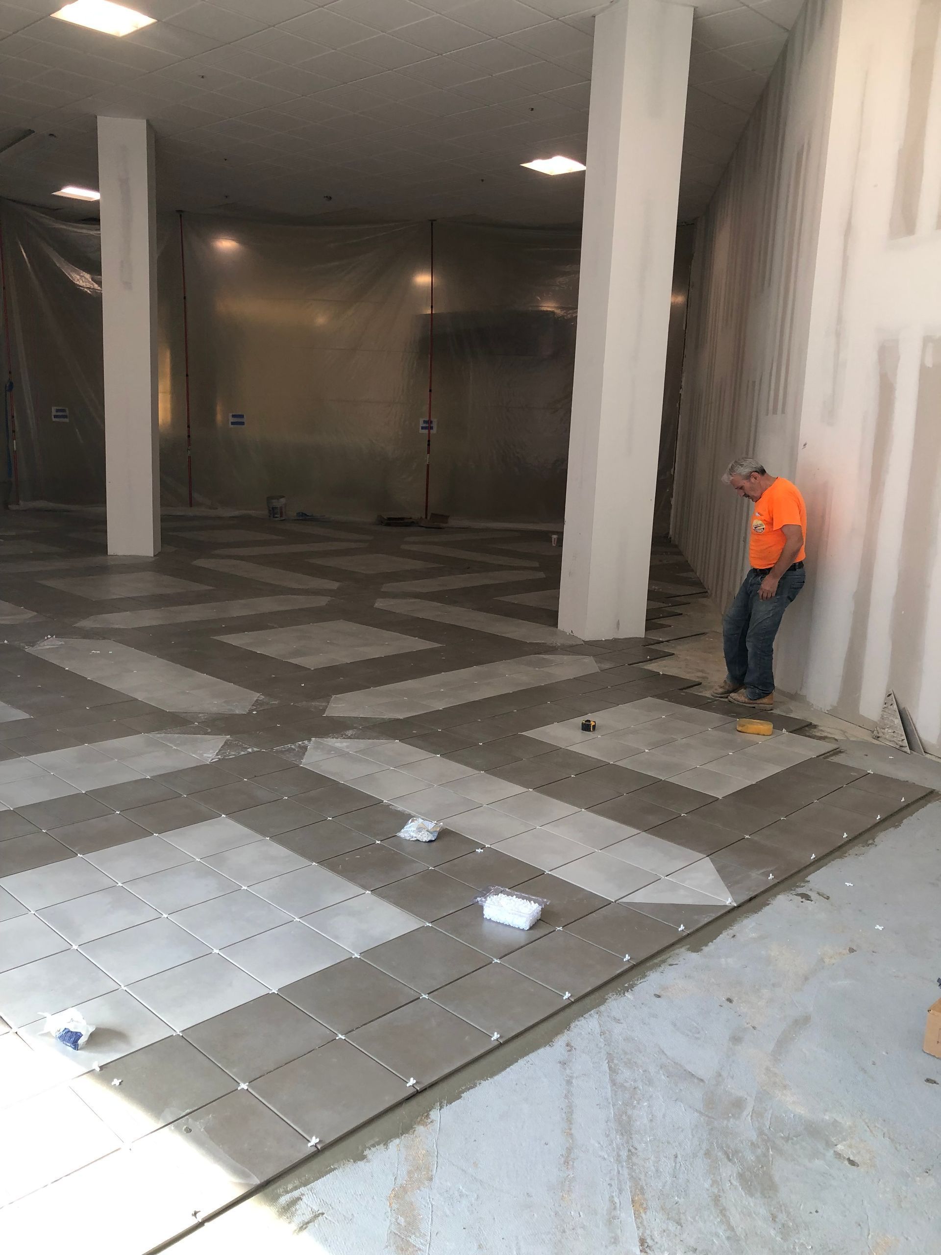 A man is standing in a large empty room.