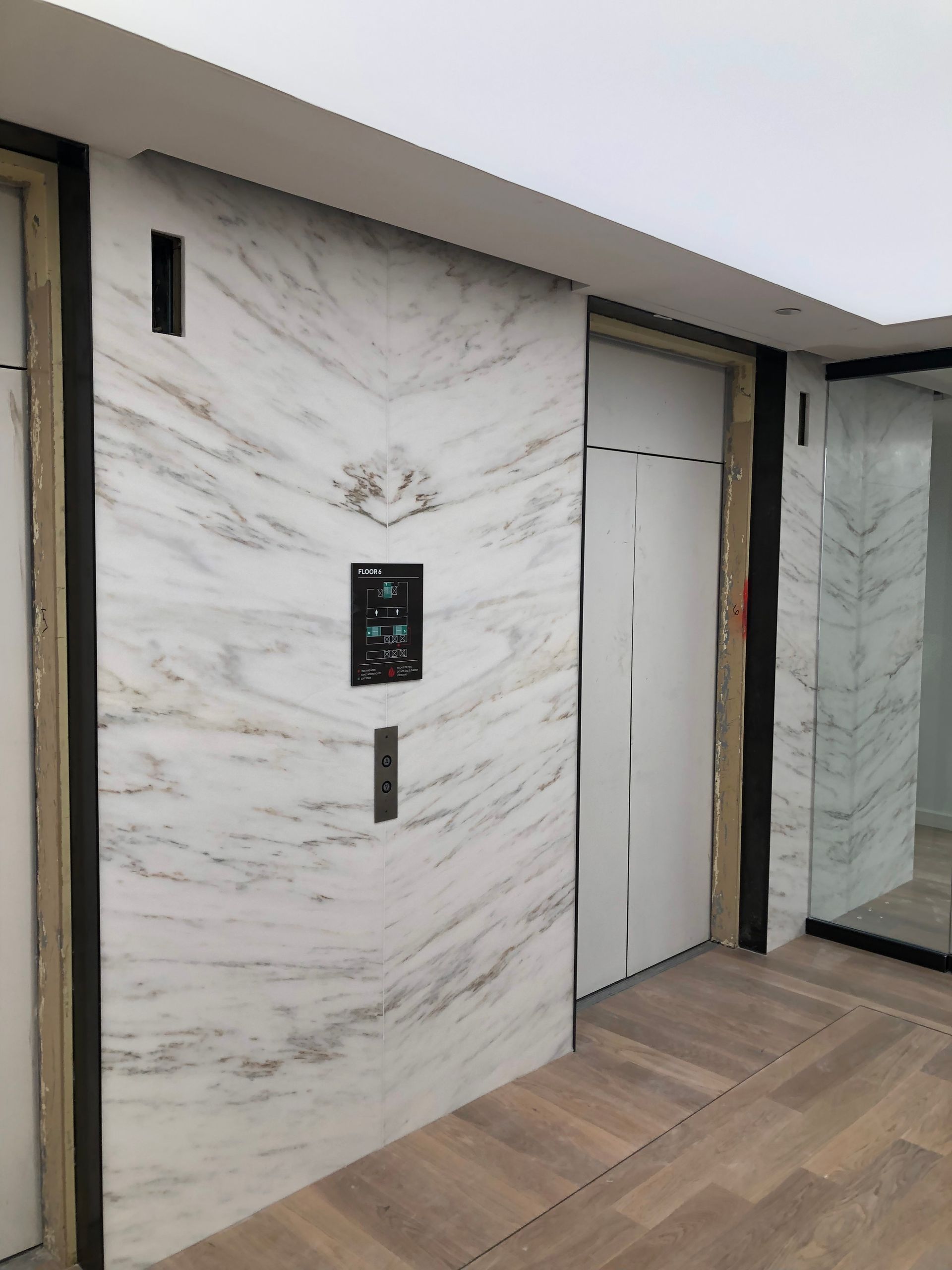 A hallway with marble walls and wooden floors