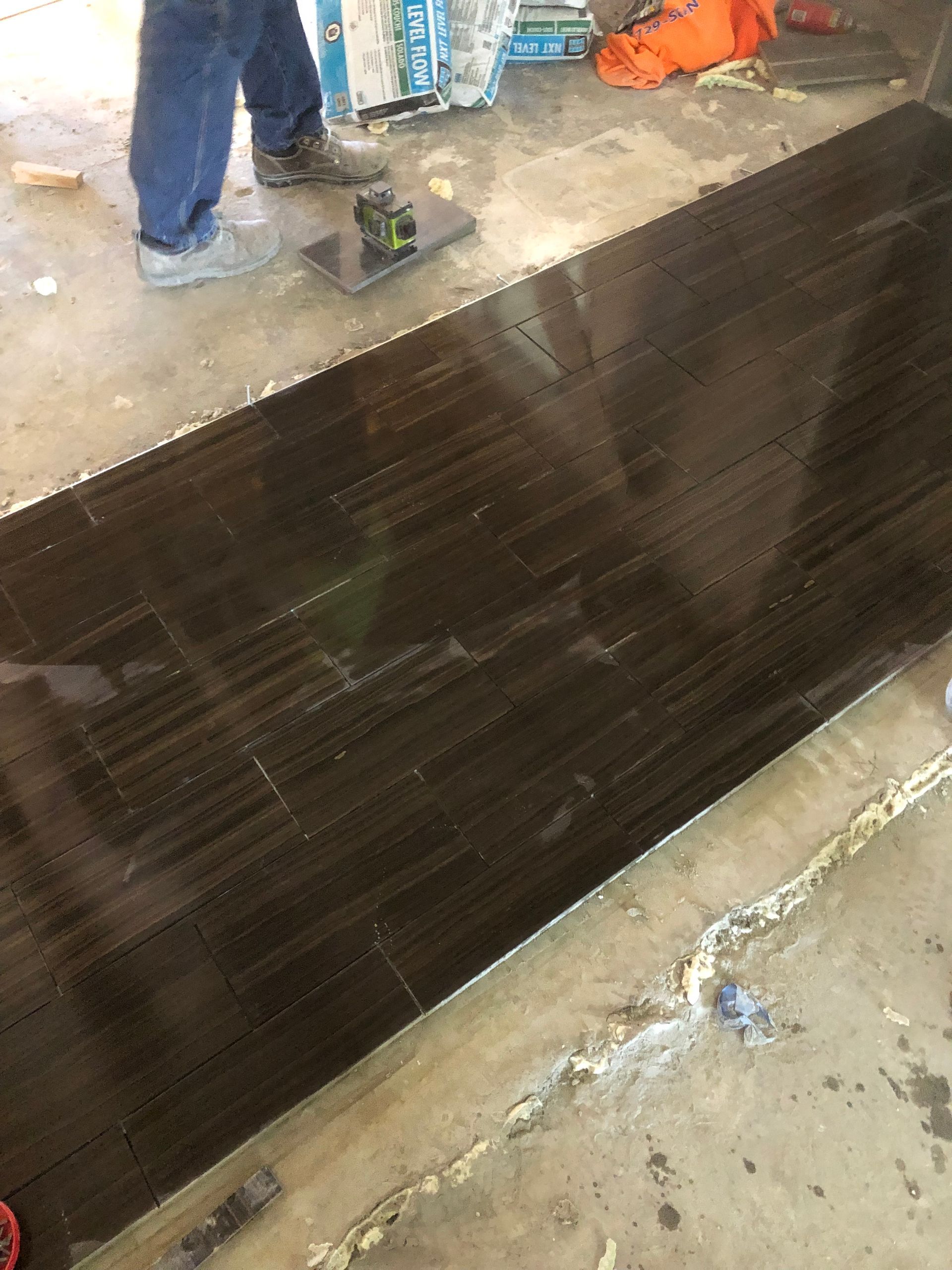 A person is standing on a black tile floor.