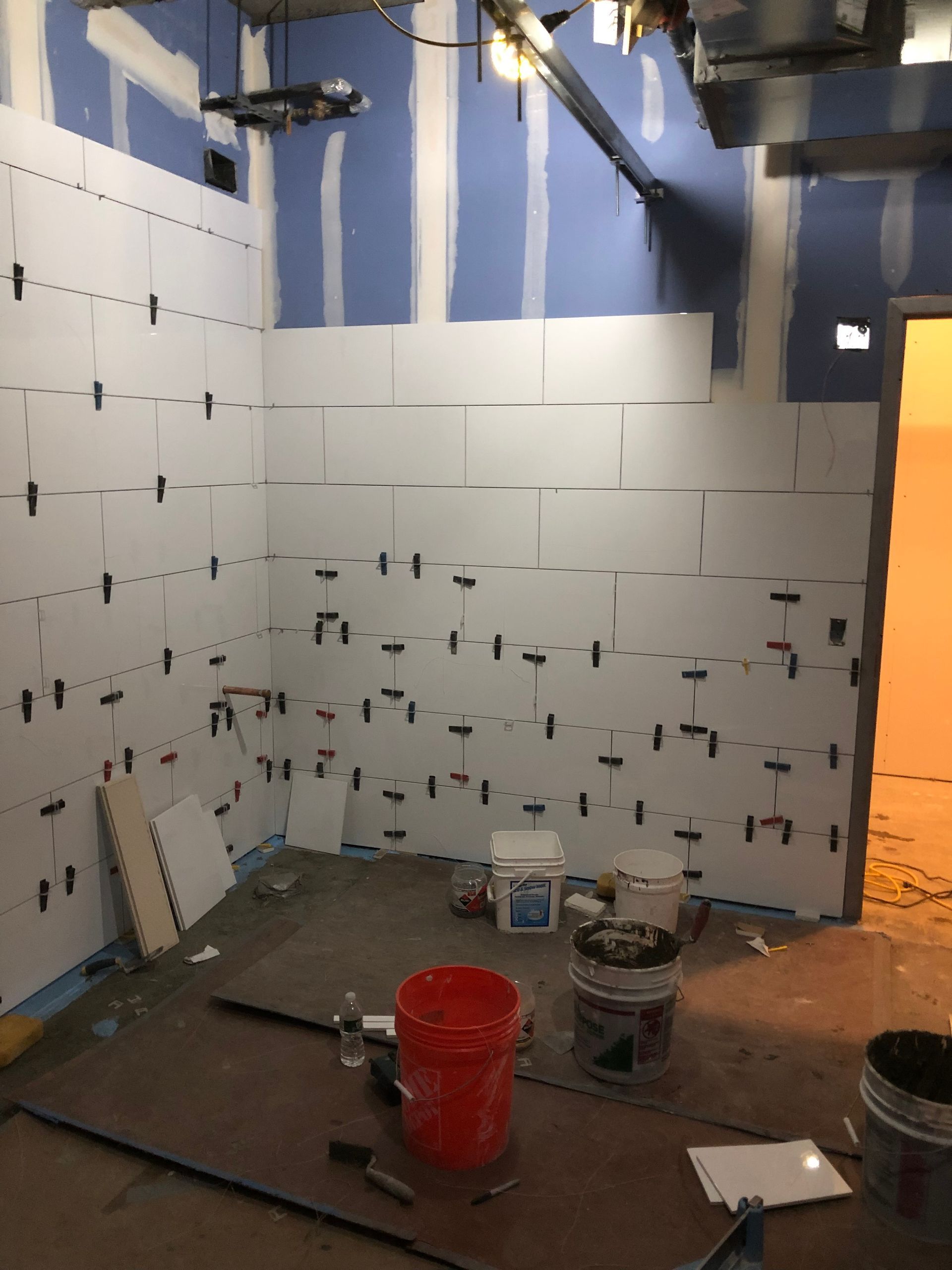 A room under construction with a red bucket on the floor