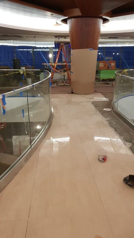 A building under construction with a staircase and a glass railing.