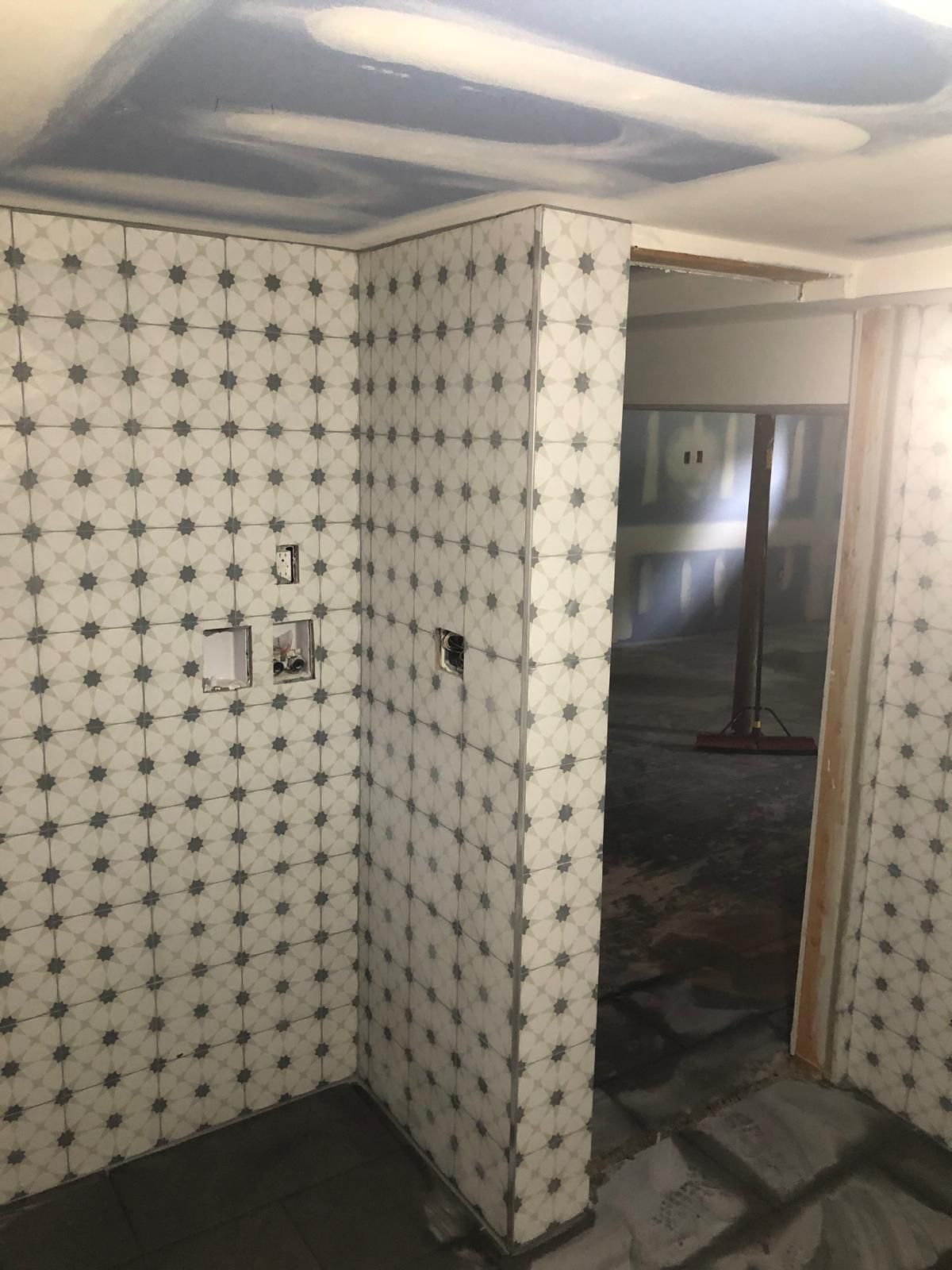A room with a lot of white tiles on the walls