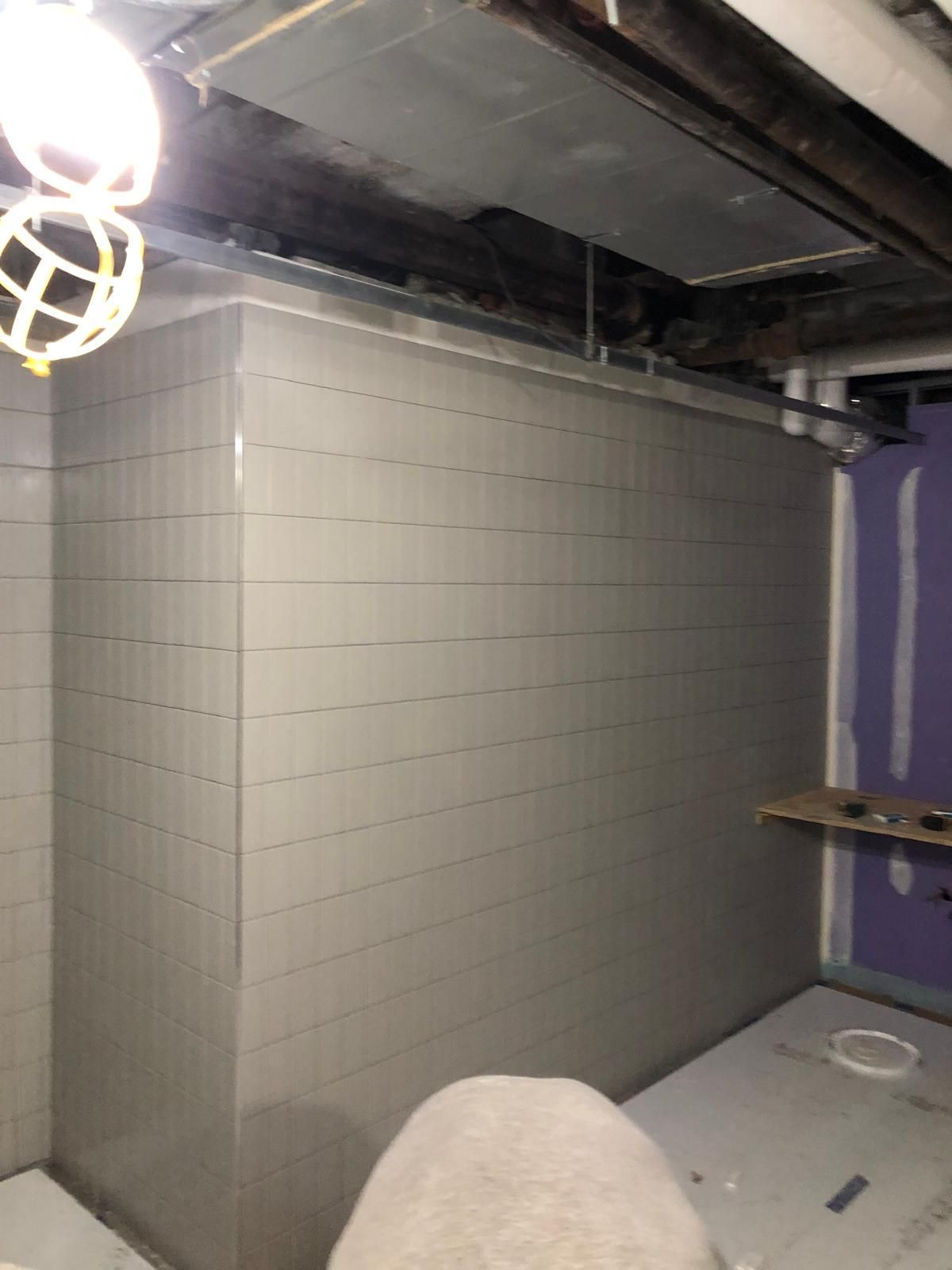 A room with a ceiling fan and a purple wall.