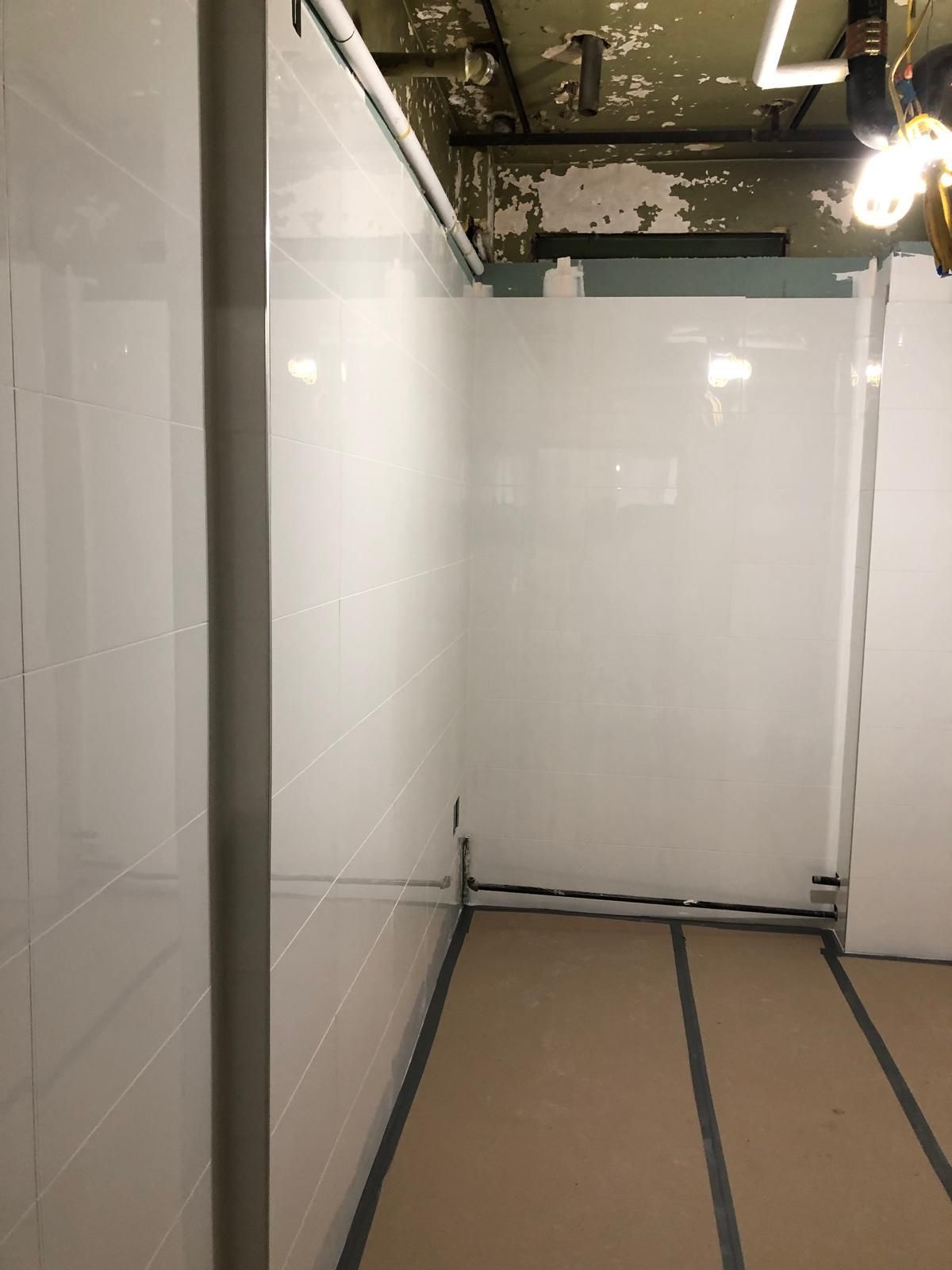 A room with a white wall and a brown floor