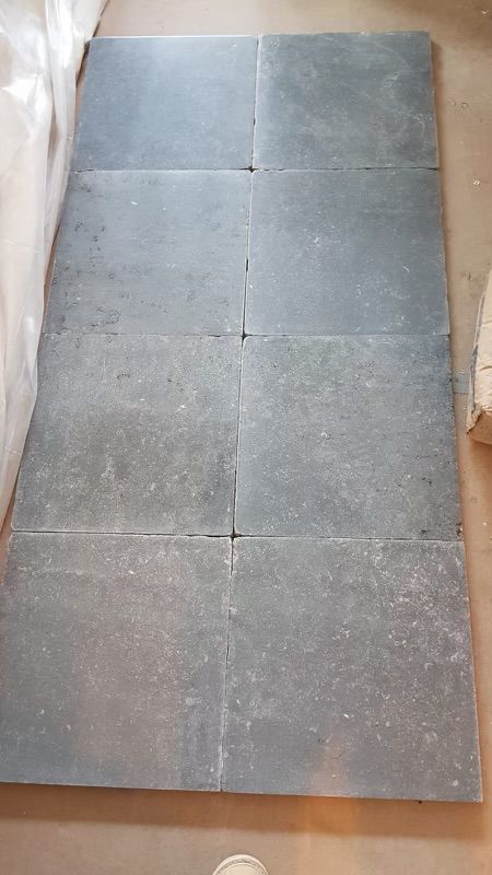 A bunch of tiles are laying on the floor in a room.
