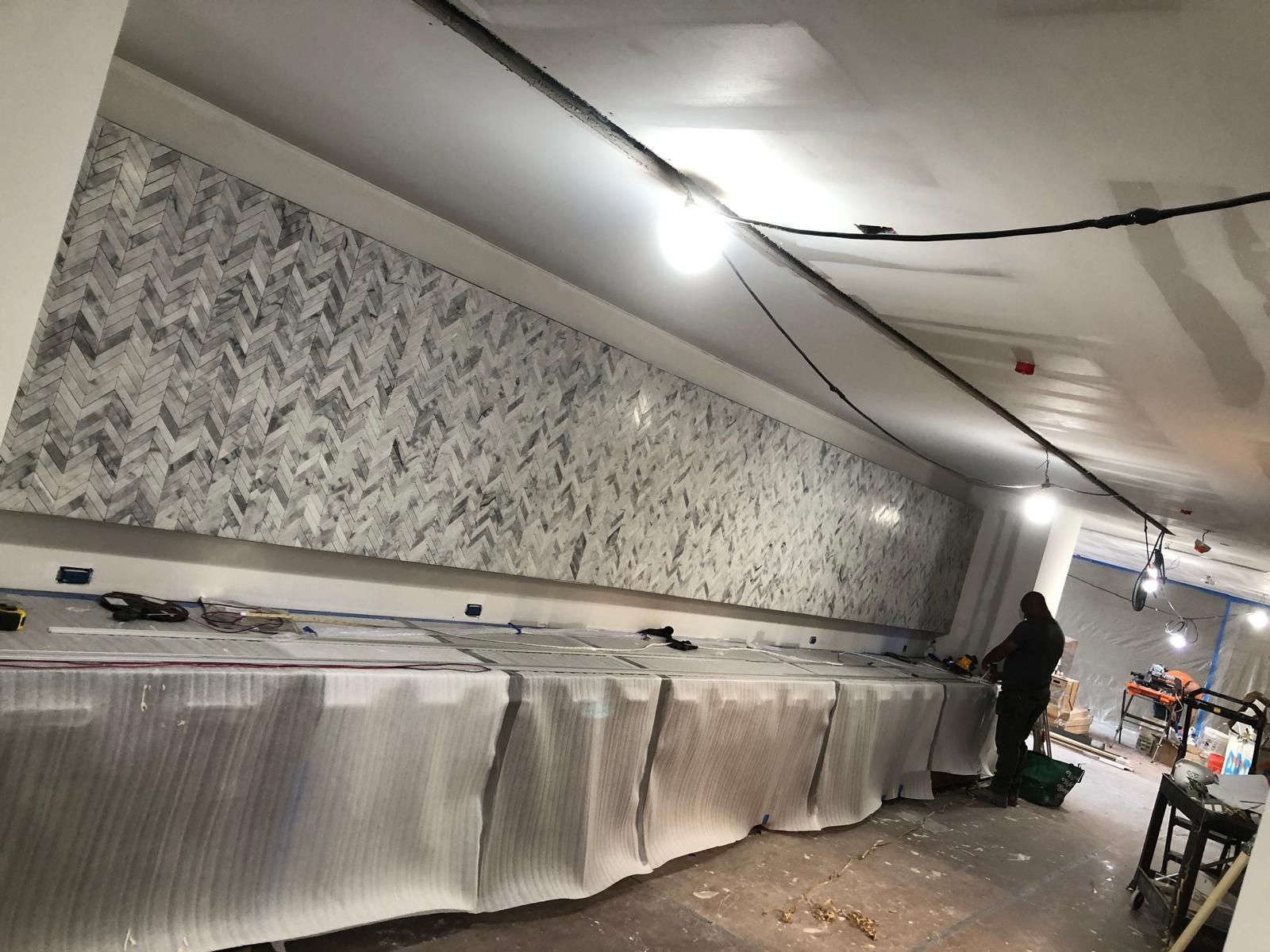 A man is standing in a room with a lot of boxes on the floor.