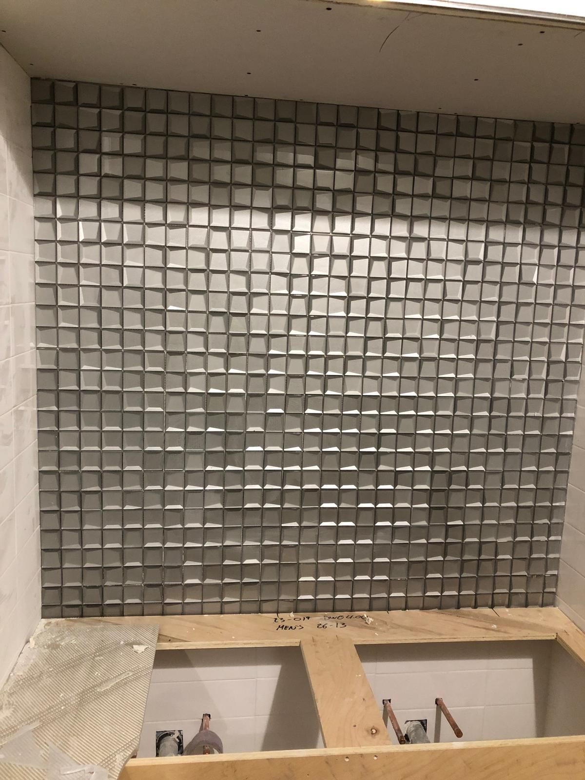 A wall with a lot of square tiles on it