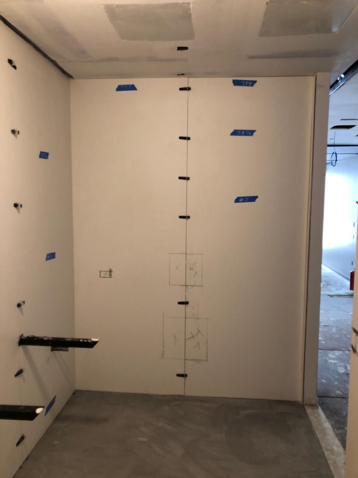 A room with a white wall and blue tape on it