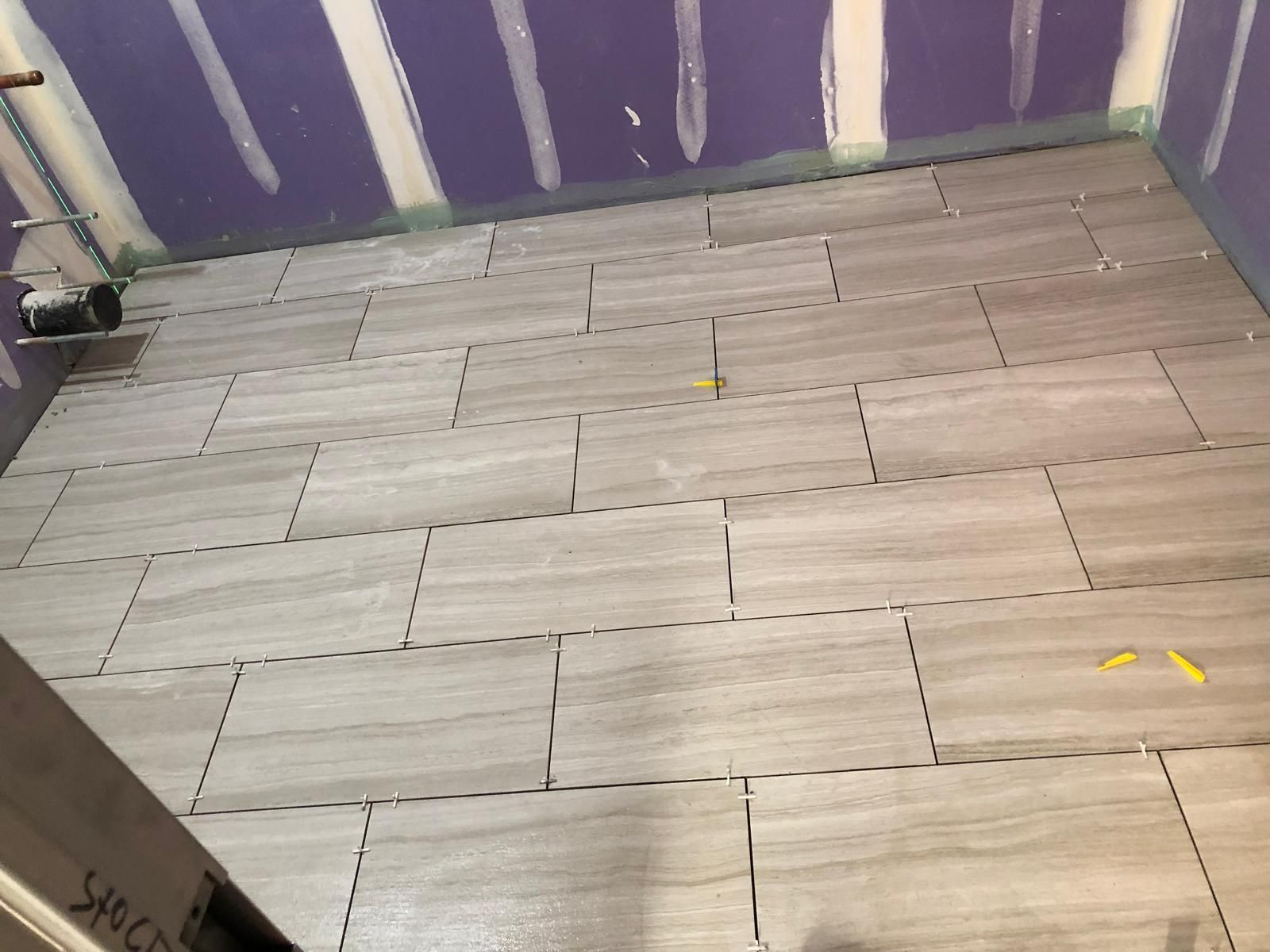 A tiled floor in a room with purple walls