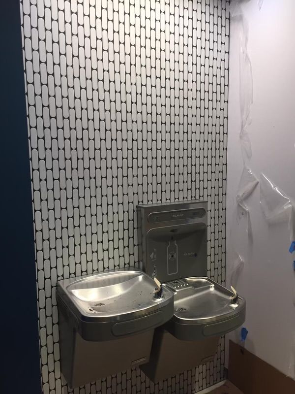 A bathroom with two sinks and a tiled wall