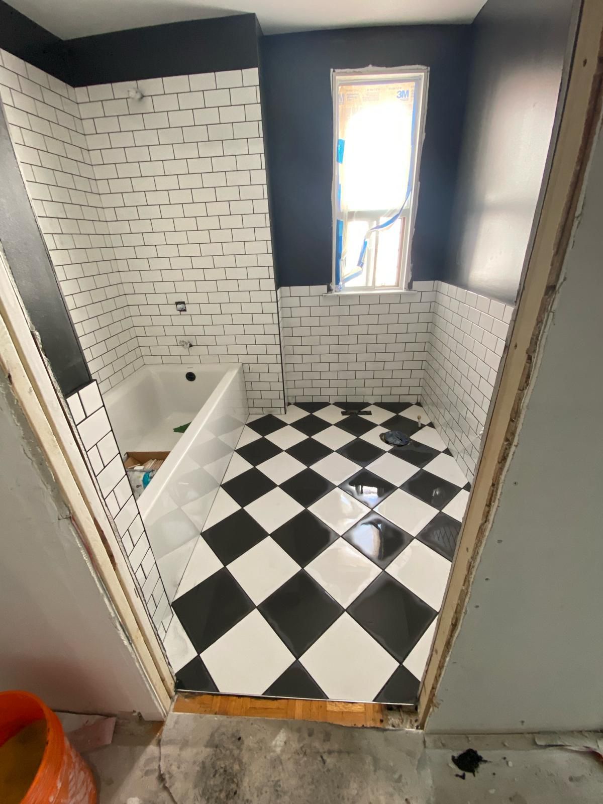 A bathroom with a black and white checkered floor