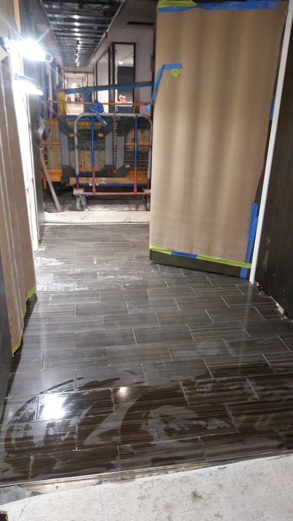A hallway with a tiled floor in a building under construction.