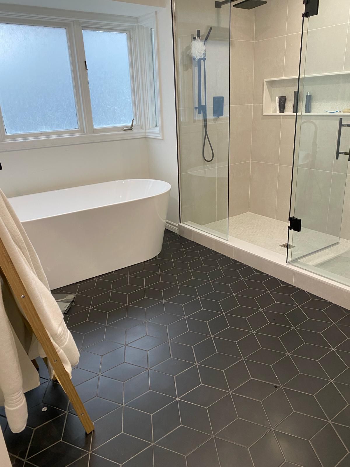 A bathroom with a tub , shower , and window.