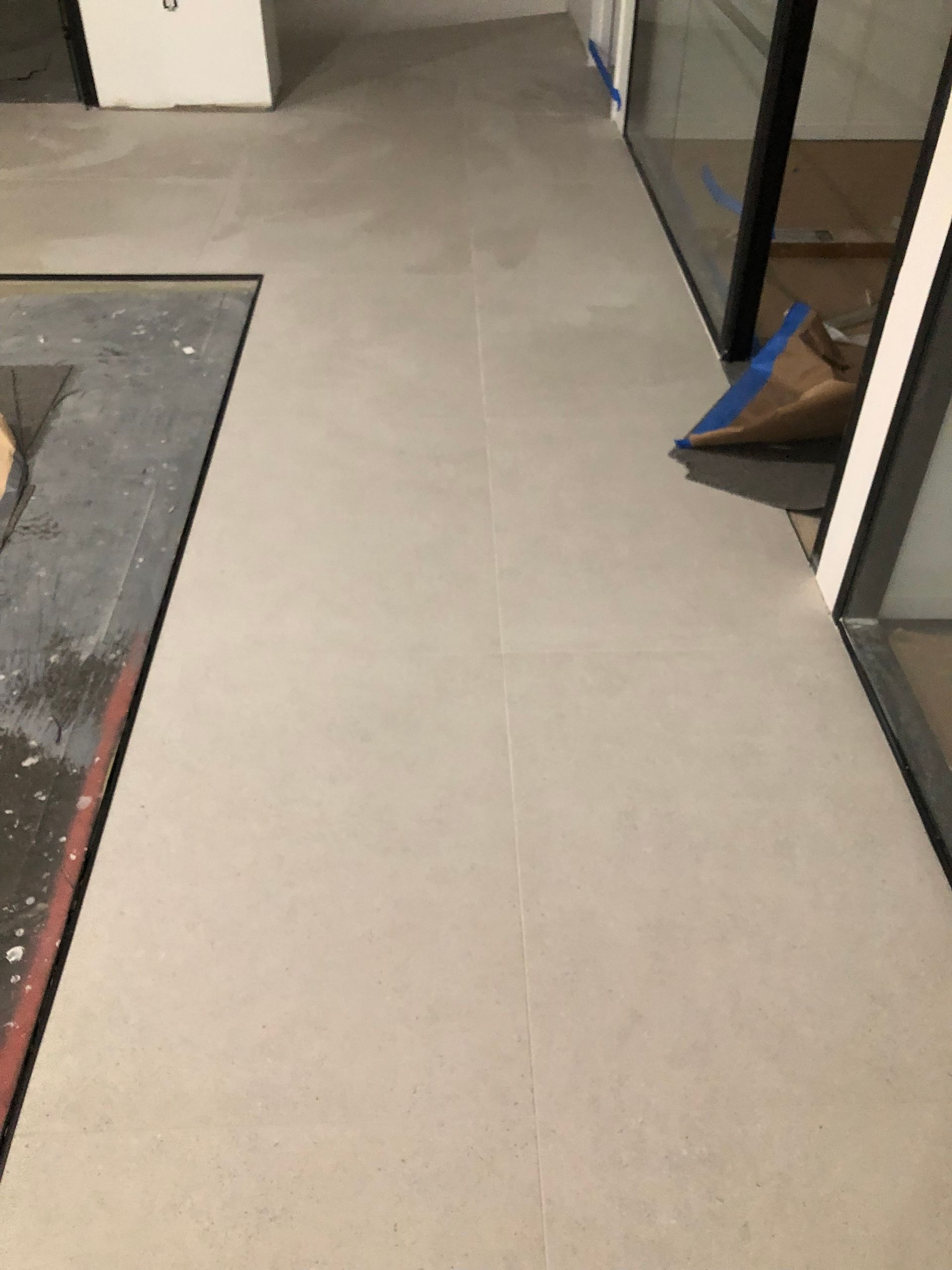 A white tile floor in a room with a sliding glass door.