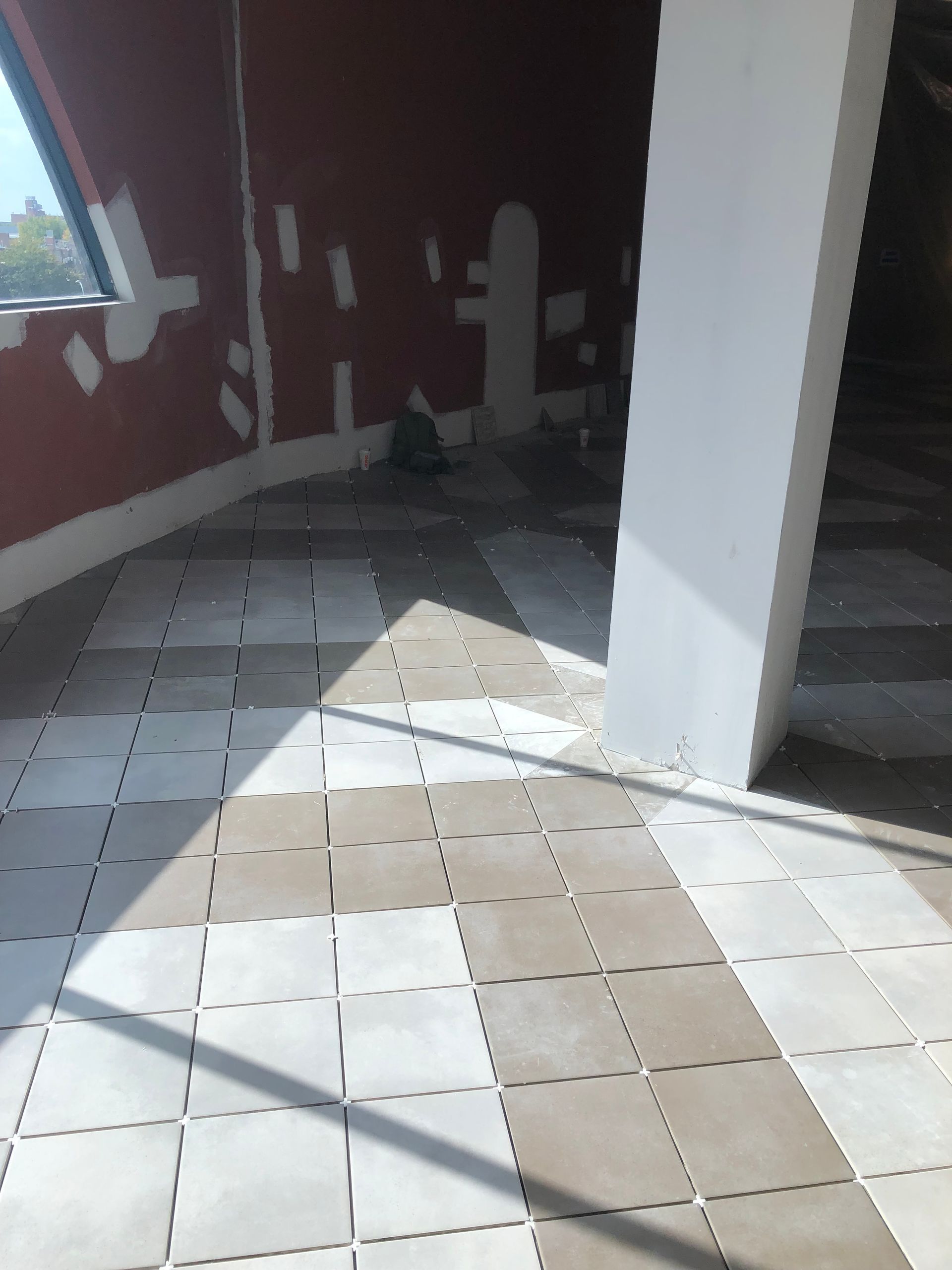 A room with tiles on the floor and a window