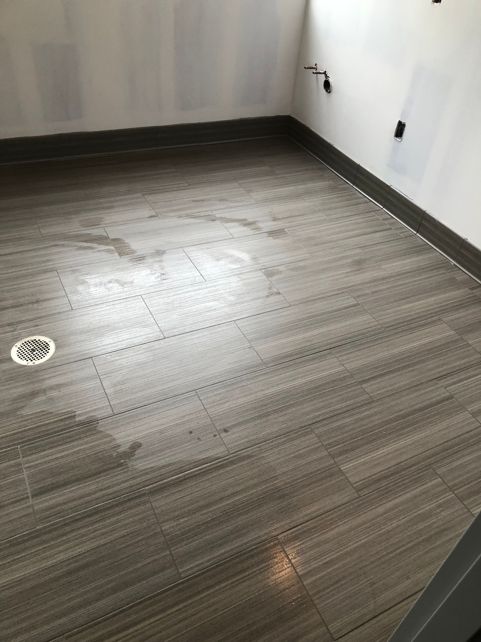 A room with a wooden floor and a white wall.