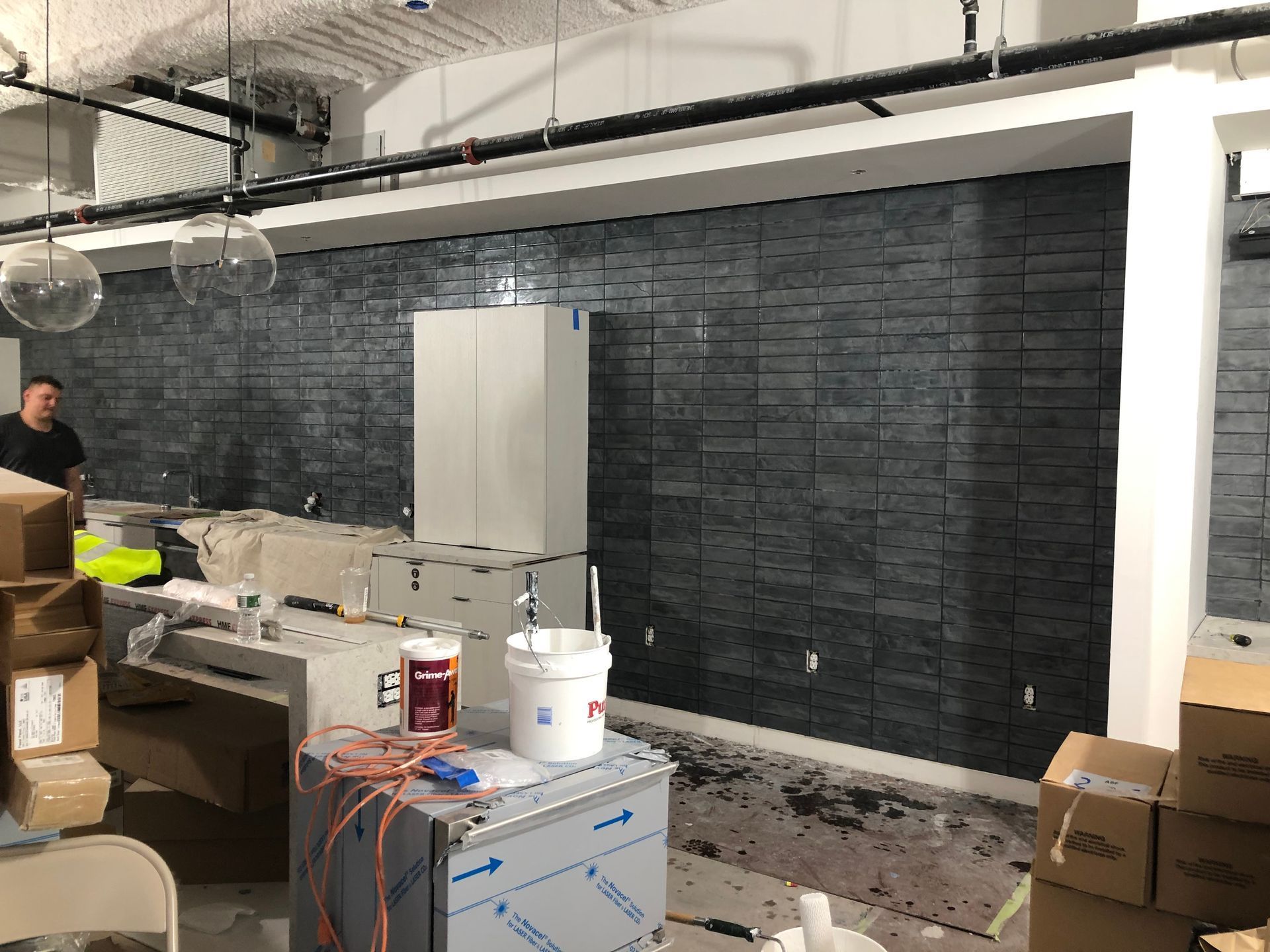 A man is standing in a room with boxes on the floor.