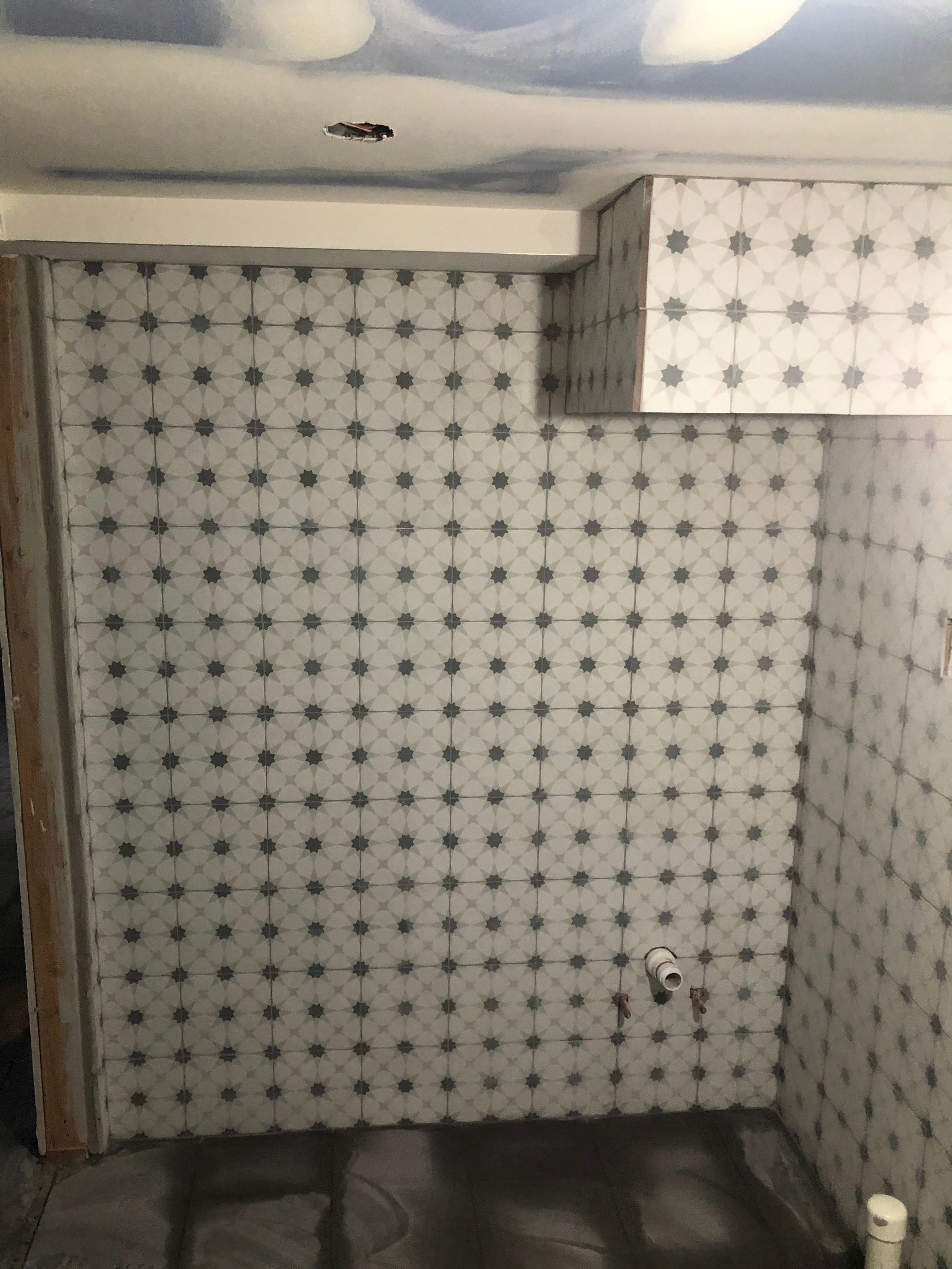 A bathroom with a lot of tiles on the wall.