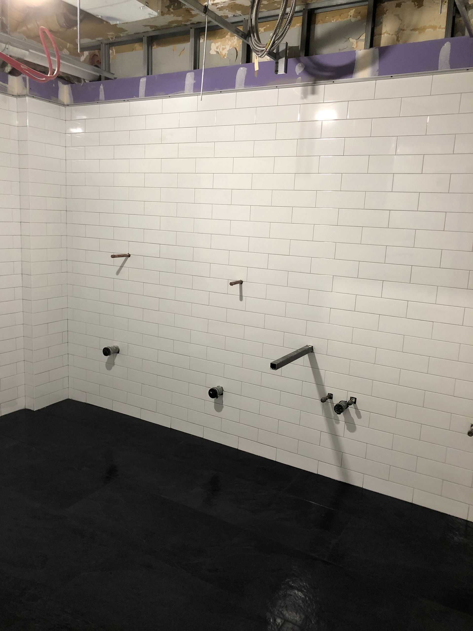 A room with white brick walls and a black floor