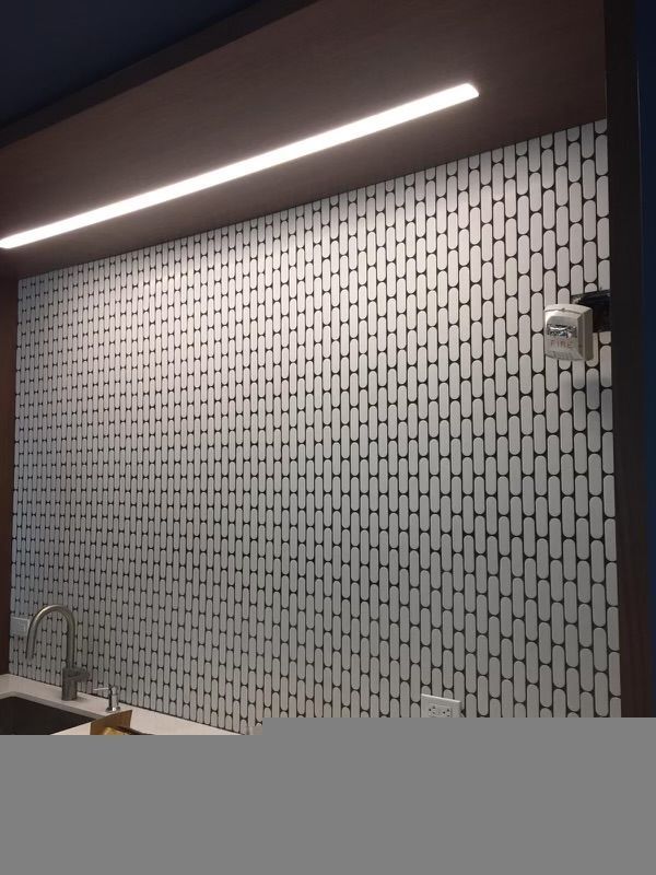 A kitchen with a tiled wall and a sink
