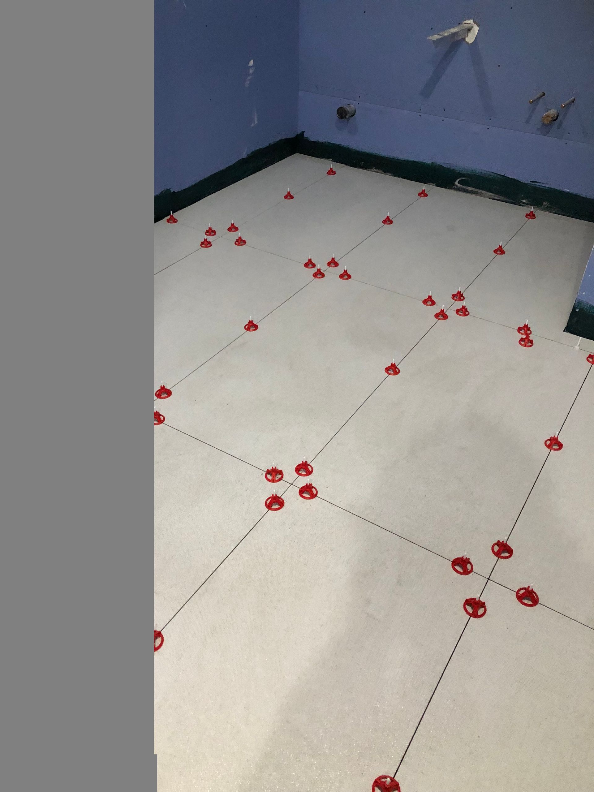 A white tile floor with red dots on it