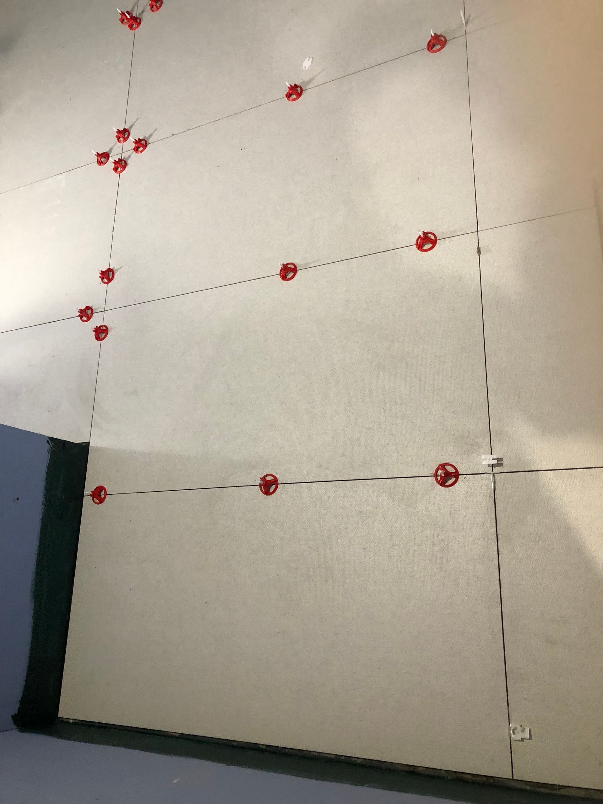 A white wall with a lot of red dots on it