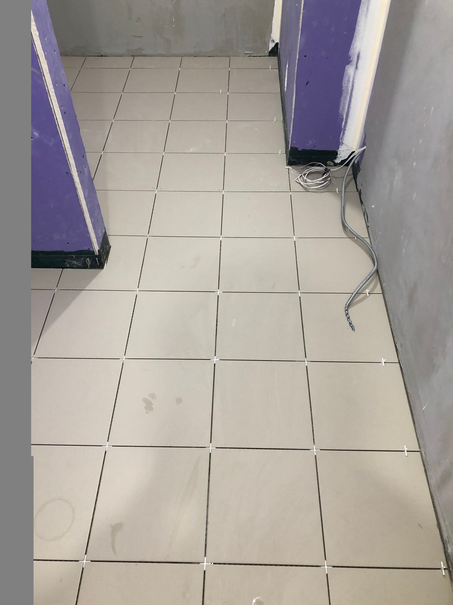 A bathroom with white tiles and purple walls
