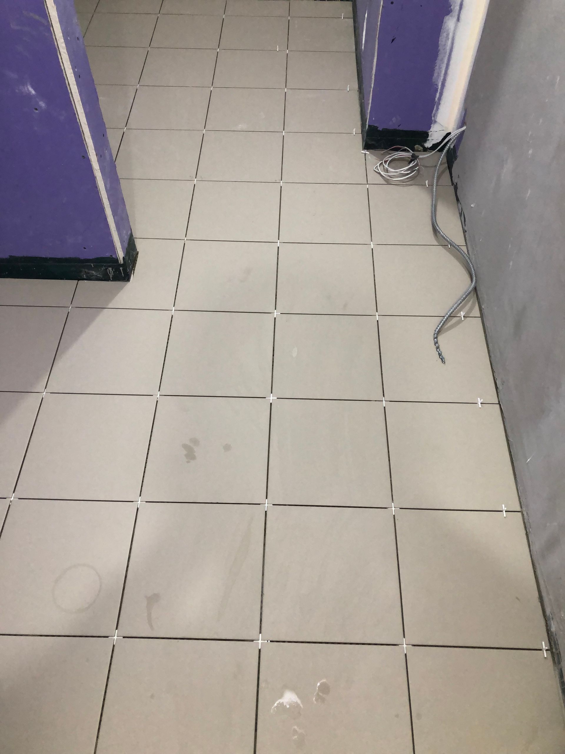 A tiled floor in a room with purple walls