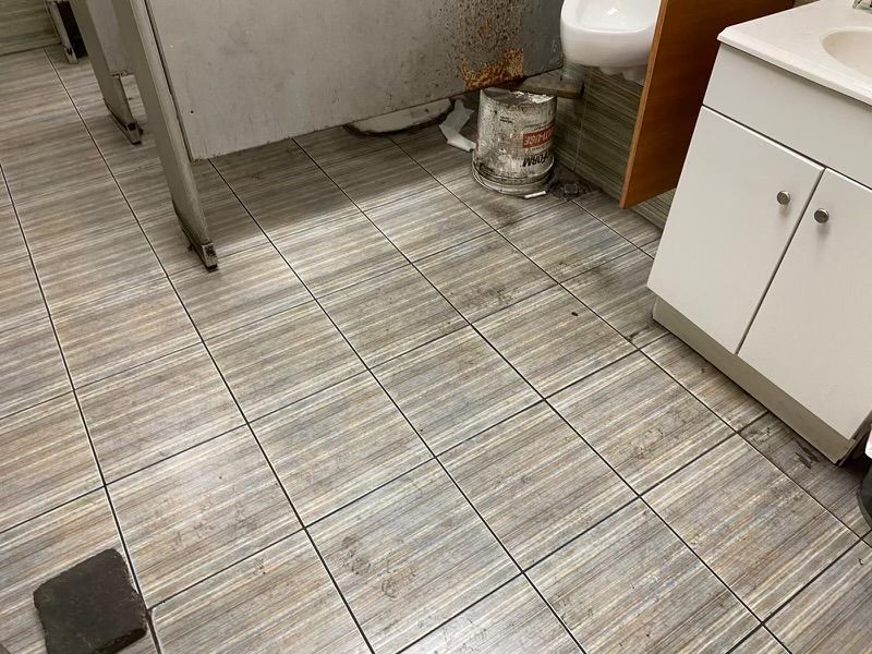 A bathroom with tile floors , a sink , and a toilet.