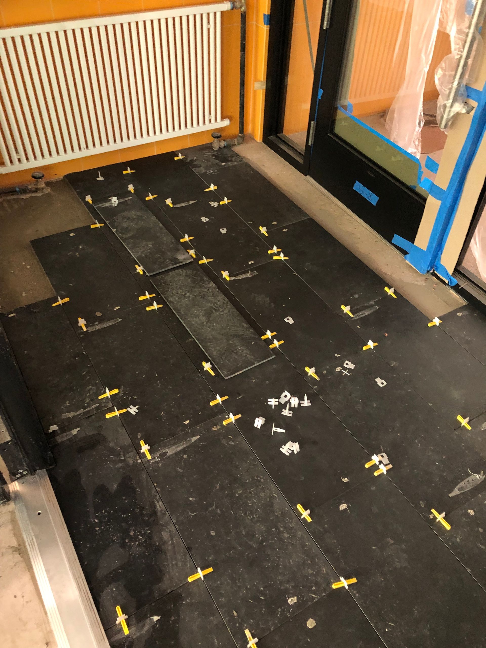 A dirty floor with a radiator and a door in the background