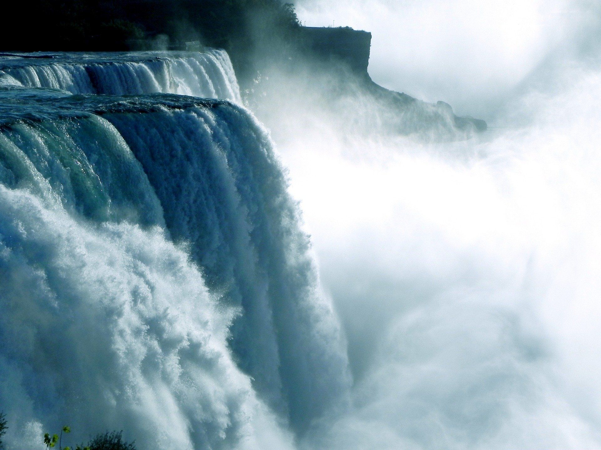 A waterfall is surrounded by a cloudy sky