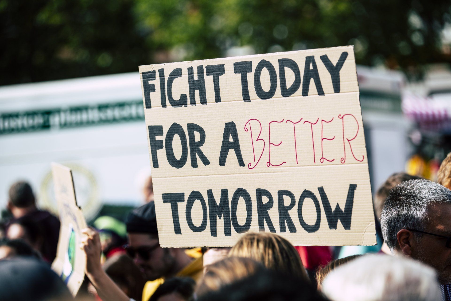 A group of people are holding a sign that says `` fight today for a better tomorrow ''.