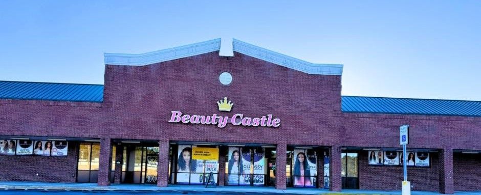 Beauty Castle store with a brick facade and posters in the windows under a blue sky.