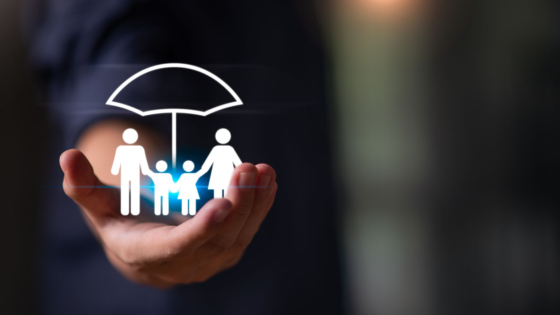 A hand holding a graphic of a family under an umbrella, symbolizing insurance and protection.