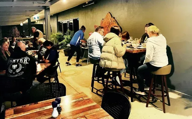 People Seated at Tables in a Dimly Lit Outdoor Restaurant — Pt Cartwright Seafoods in Warana, QLD