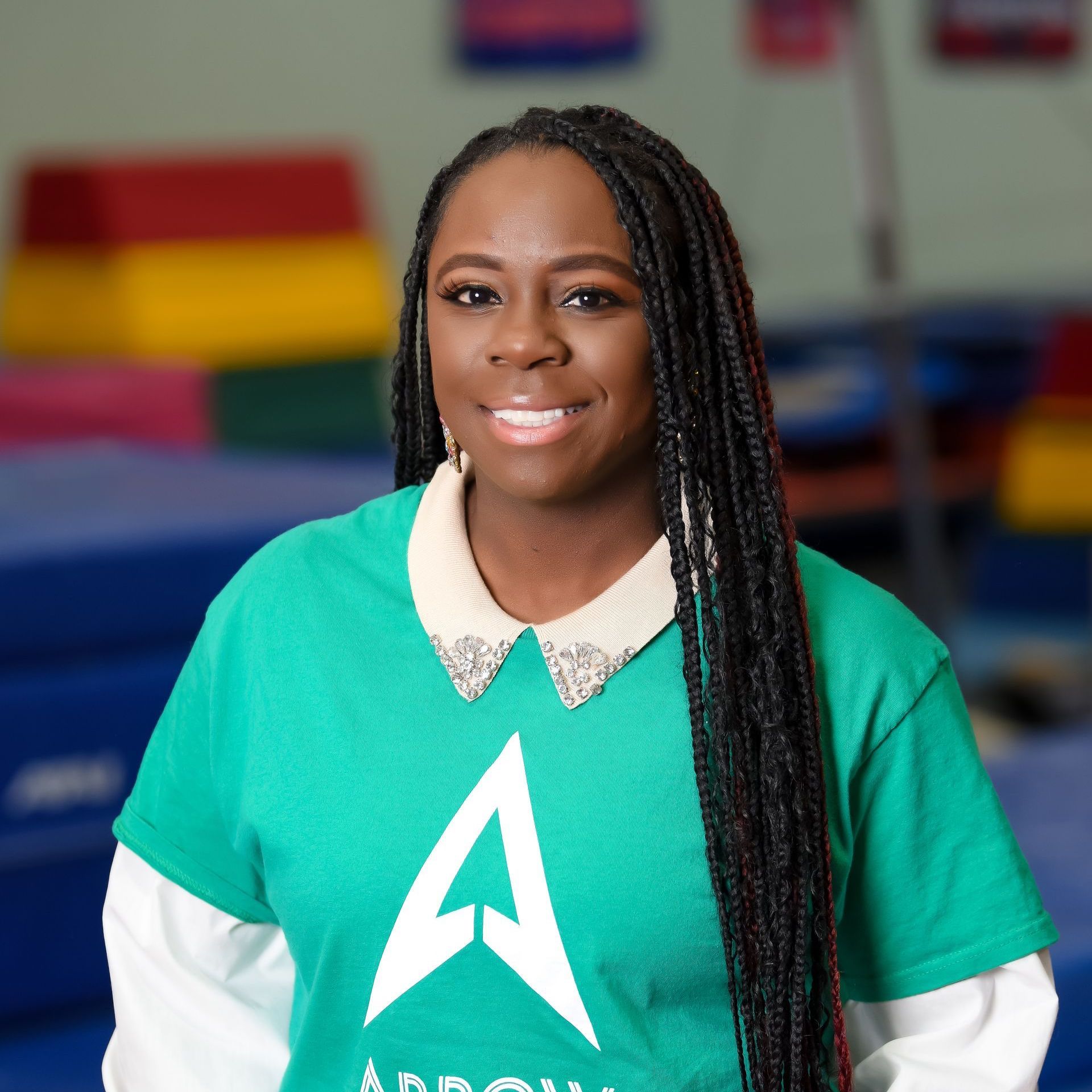 A woman wearing a green shirt with the letter a on it