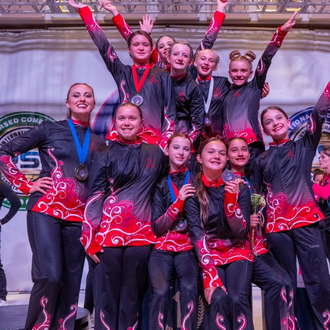 A group of girls are posing for a picture with their arms in the air