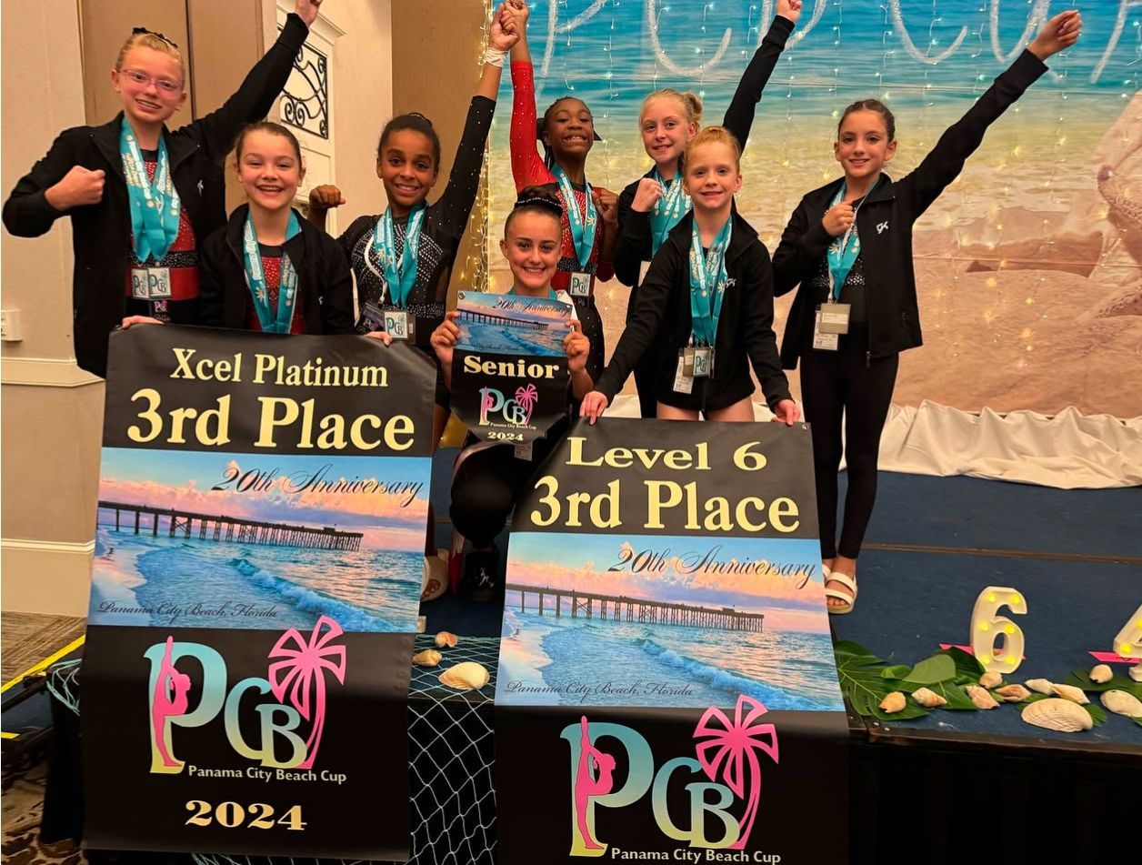 A group of young girls are standing on a stage holding signs that say 3rd place and level 6 3rd place.